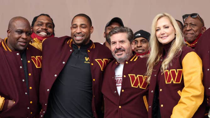 Commanders Team co-owners Dan and Tanya Snyder pose for a photo with former team members after changing the team's name following pressure from the NFL and Roger Goodell.