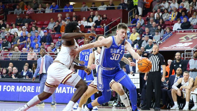 Duke Blue Devils C Kyle Filipowski drives past Boston College Eagles G Prince Aligbe at Conte Forum in Chestnut Hill, Massachusetts.