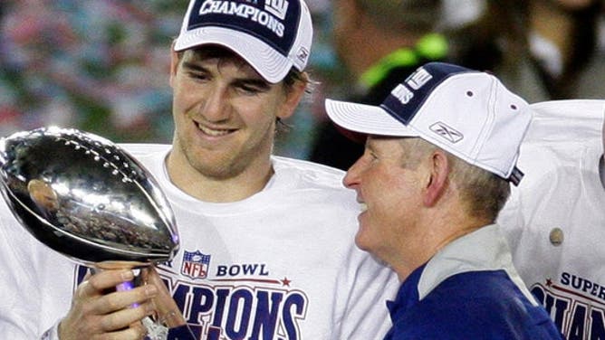 This Feb. 3, 2008, file photo shows New York Giants quarterback Eli Manning, left, and his coach Tom Coughlin looking at the Vince Lombardi Trophy as they celebrate after the Giants beat the New England Patriots 17-14 in Super Bowl XLII in Glendale, Ariz.