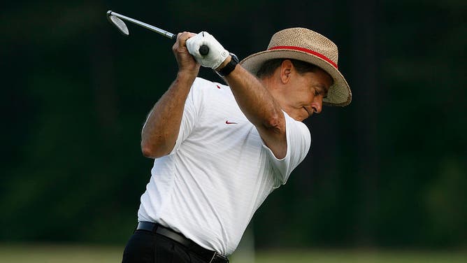 Former Alabama head football coach Nick Saban hits some balls at the driving range.