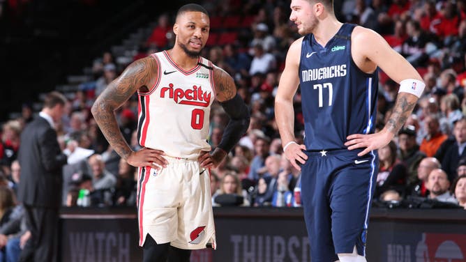 Portland Trail Blazers' Damian Lillard talks with Dallas Mavericks' Luka Doncic at the Moda Center Arena in Portland, Oregon.