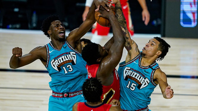 New Orleans Pelicans' Zion Williamson is blocked Memphis Grizzlies' bigs Brandon Clarke and Jaren Jackson Jr. at HP Field House at ESPN Wide World Of Sports Complex in Lake Buena Vista, Florida.