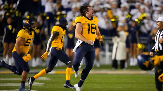 West Virginia celebrates. Clay Travis college football gambling picks.