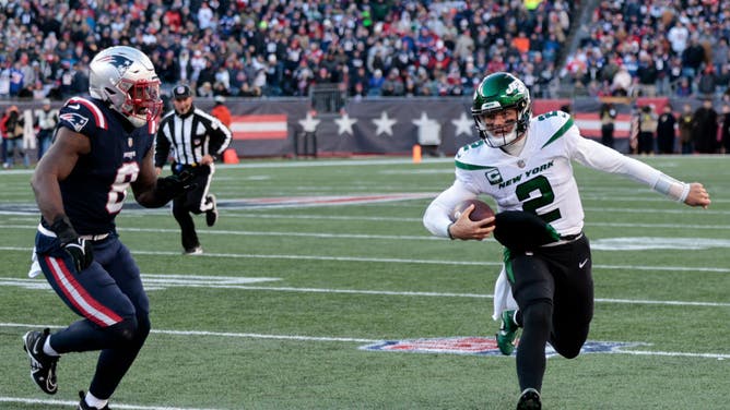 New York Jets QB Zach Wilson evades New England Patriots LB Ja'Whaun Bentley at Gillette Stadium in Foxborough, Massachusetts.