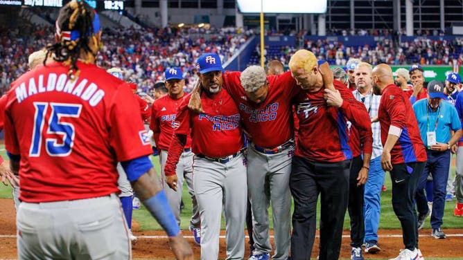 Puerto Rico pitcher Edwin Diaz is being helped by team pitching coach and medical staff after suffering a postgame injury. Diaz and Jose Altuve both suffered injuries at the event.