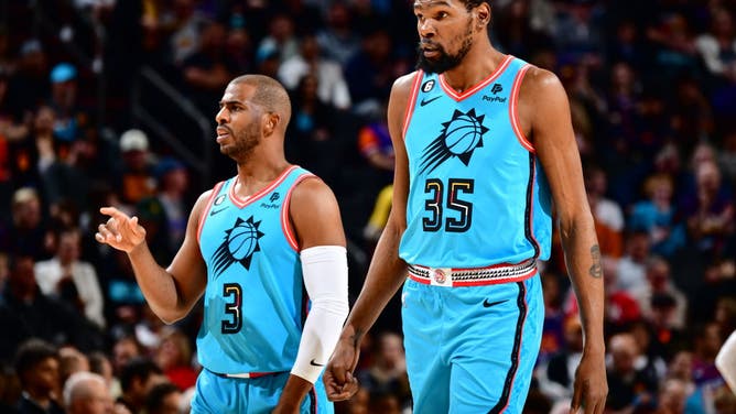 Kevin Durant and Chris Paul stand on the court during a game vs. the Spurs at Footprint Center in Phoenix, Arizona.