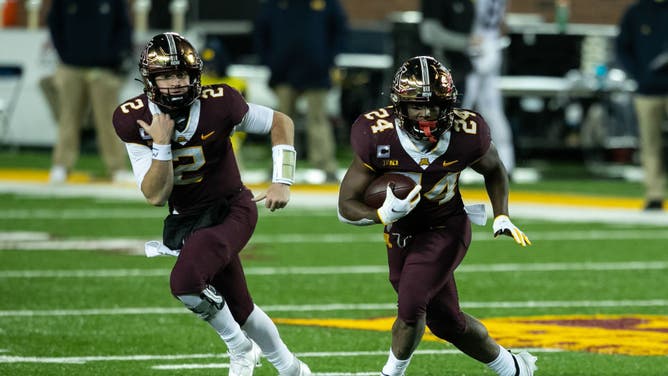 Minnesota Golden Gophers RB Mohamed Ibrahim carries the ball while QB Tanner Morgan acts as a diversion against the Michigan Wolverines at TCF Bank Stadium in Minneapolis.
