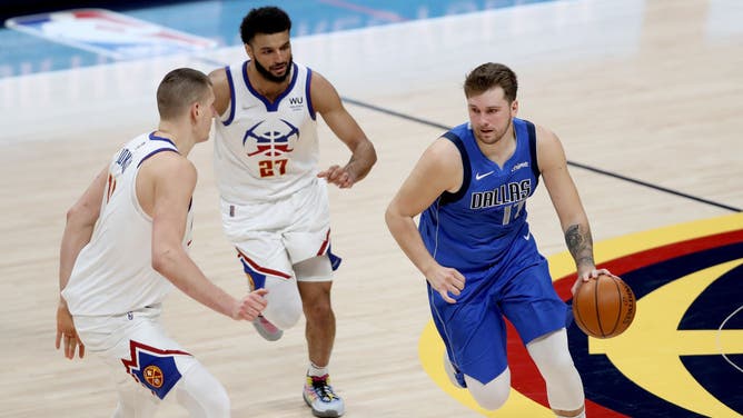 Dallas Mavericks PG Luka Doncic drives against Denver Nuggets C Nikola Jokic and PG Jamal Murray at Ball Arena in Denver, Colorado.