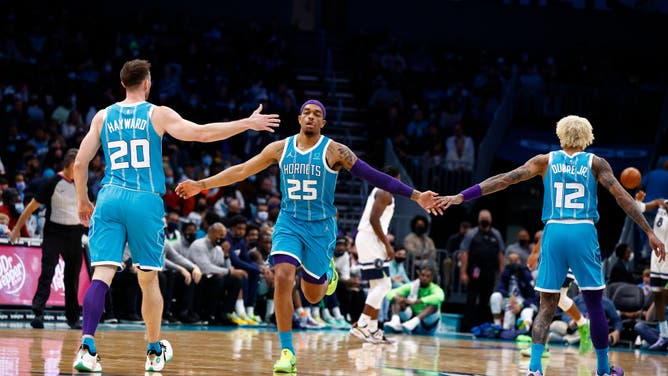 Hornets forwards P.J. Washington high-fives teammates Gordon Hayward and Kelly Oubre Jr. at Spectrum Center in Charlotte, North Carolina.
