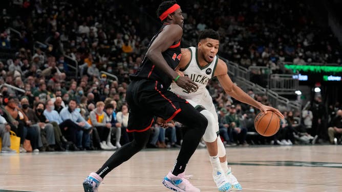 Milwaukee Bucks SF Giannis Antetokounmpo dribbles the ball against Toronto Raptors F Pascal Siakam at Fiserv Forum in Milwaukee, Wisconsin.