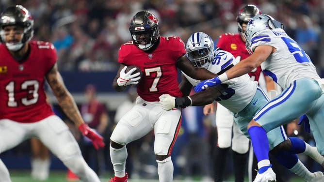 Buccaneers RB Leonard Fournette attempts to escape the tackle by Cowboys edge rusher DeMarcus Lawrence at AT&T Stadium in Arlington, Texas.