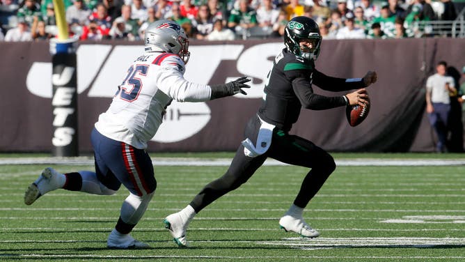 New York Jets QB Zach Wilson scrambling away from New England Patriots defensive linemen Daniel Ekuale at MetLife Stadium in East Rutherford, New Jersey.