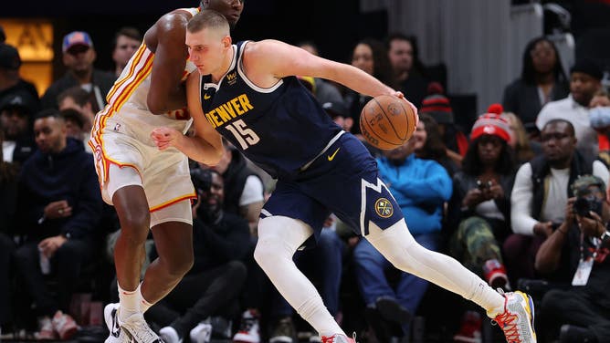 Hawks big Clint Capela defends Denver Nuggets big Nikola Jokic in an NBA game at State Farm Arena in Atlanta.