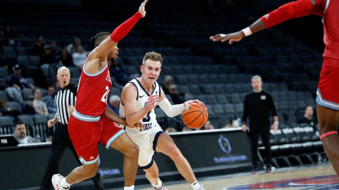 Utah State Aggies G Steven Ashworth drives past Loyola Marymount Lions G Cam Shelton at Michelob ULTRA Arena in Las Vegas, Nevada.