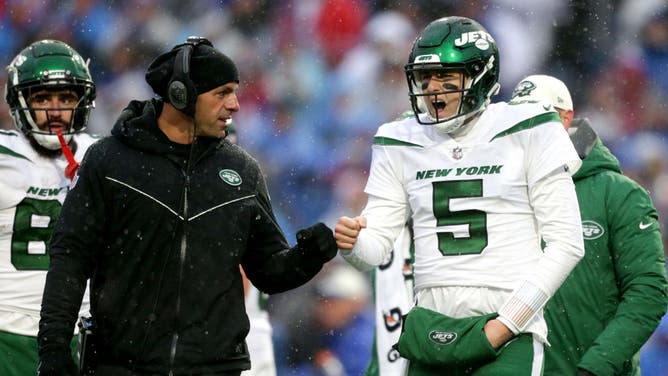 New York Jets QB Mike White fist bumps coach Robert Saleh in the 2nd quarter of a game against the Buffalo Bills at Highmark Stadium in Orchard Park, New York.