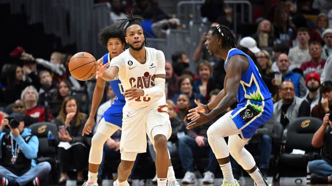 Cleveland Cavaliers PG Darius Garland passes around Milwaukee Bucks PG Jrue Holiday at Rocket Mortgage Fieldhouse in Cleveland, Ohio.