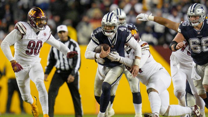 Cowboys QB Dak Prescott is tackled by Commanders DT Daron Payne at FedExField in Landover, Maryland.