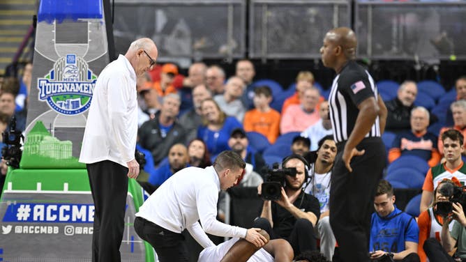 Miami head coach Jim Larrañaga checks on Hurricanes F Norchad Omier after rolling his ankle during the ACC Tournament semifinals vs. Duke at Greensboro Coliseum Complex in Greensboro, North Carolina.