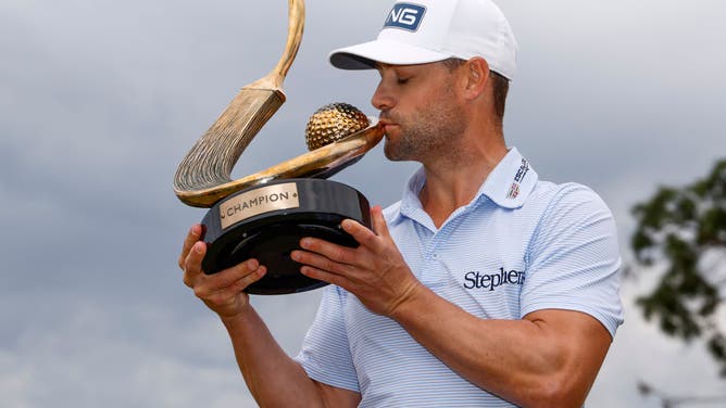 Taylor Moore celebrates with the trophy after winning The 2023 Valspar Championship at Innisbrook Resort and Golf Club in Palm Harbor, Florida.