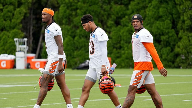 Tee Higgins #5, Tyler Boyd #83, and Ja'Marr Chase #1 of the Cincinnati Bengals walk across the field during training camp at Kettering Health Practice Fields on July 26, 2023 in Cincinnati, Ohio.