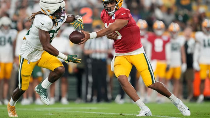 Green Bay QB Jordan Love hands the ball off to RB Aaron Jones during Packers Family Night at Lambeau Field.