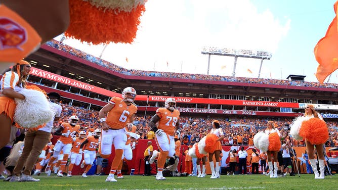 Baker Mayfield and Tristan Wirfs of the Tampa Bay Buccaneers run onto the field in their