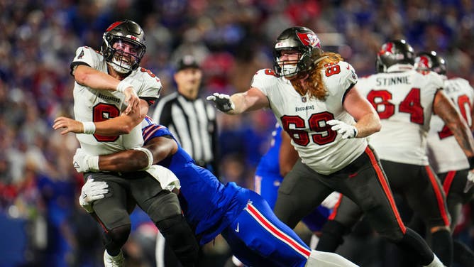 Tampa Bay Buccaneers QB Baker Mayfield passes while being hit by a Buffalo Bills pass rusher at Highmark Stadium in Orchard Park, New York.