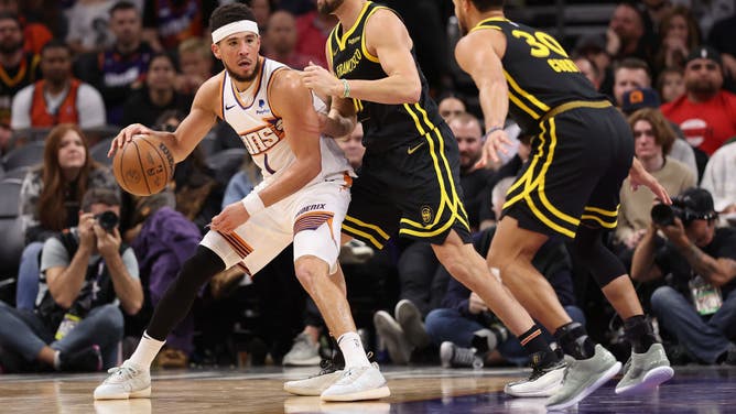Suns All-Star Devin Booker posts up Golden State Warriors SG Klay Thompson at Footprint Center in Phoenix, Arizona.