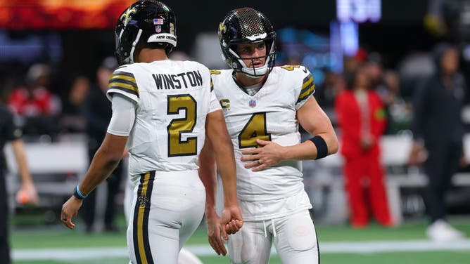 Quarterbacks Derek Carr and Jameis Winston of the New Orleans Saints warm up before the game against the Atlanta Falcons at Mercedes-Benz Stadium.