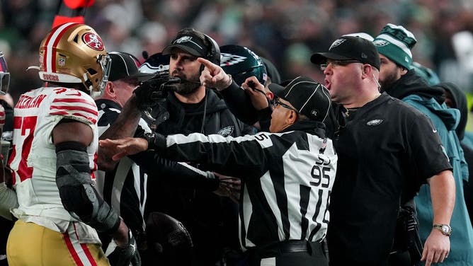 Officials steps in along the Eagles sideline, separating Dom DiSandro from Niners linebacker Dre Greenlaw