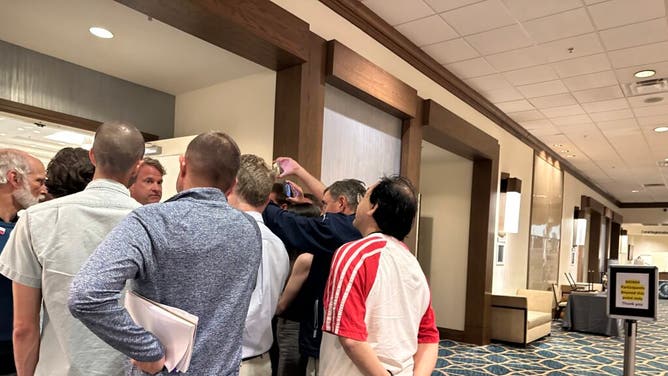 A random fan hangs around the media scrum involving Lane Kiffin