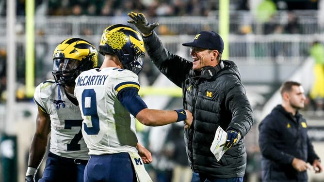 Michigan head coach Jim Harbaugh celebrates with QB J.J. McCarthy after a TD pass vs. Michigan State at Spartan Stadium in East Lansing.