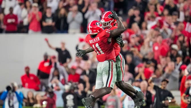 Bulldogs LBs Jalon Walker and Smael Mondon Jr. celebrate after sacking Missouri Tigers QB Brady Cook at Sanford Stadium in Athens, Georgia.