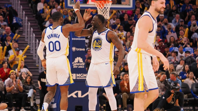 Golden State Warriors wing Jonathan Kuminga high-fives PF Draymond Green vs. the Atlanta Hawks at Chase Center in San Francisco.
