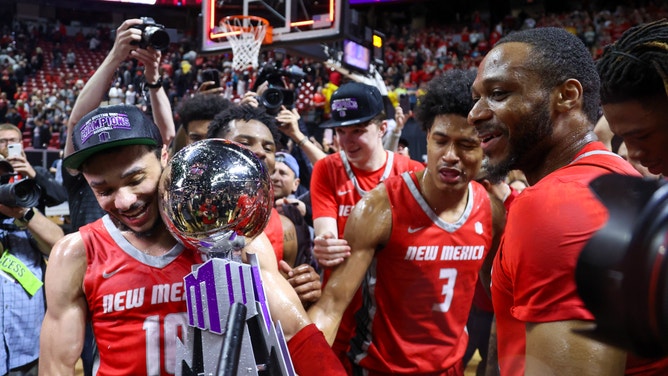 Jaelen House of the New Mexico Lobos holds the Mountain West Trophy after defeating the San Diego State Aztecs in the championship game.