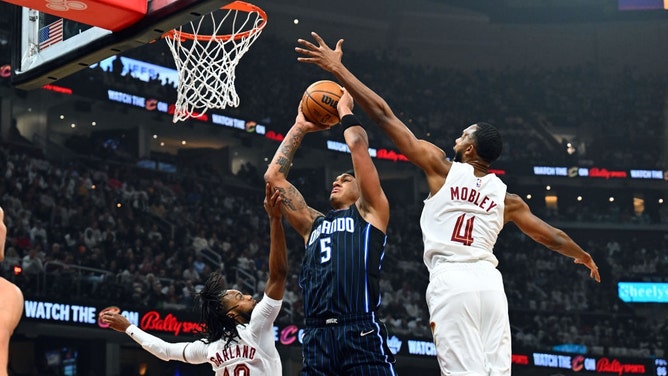 Cleveland Cavaliers big Evan Mobley tries to block Orlando Magic PG Paolo Banchero during Game 1 of the 2024 Eastern Conference First Round Playoffs at Rocket Mortgage Fieldhouse in Ohio. (Photo by Jason Miller/Getty Images)