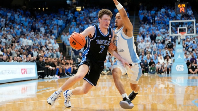 Duke Blue Devils forward Kon Knueppel drives past as North Carolina Tar Heels SG Seth Trimble at Dean E. Smith Center. (Photo credit: Bob Donnan-Imagn Images)