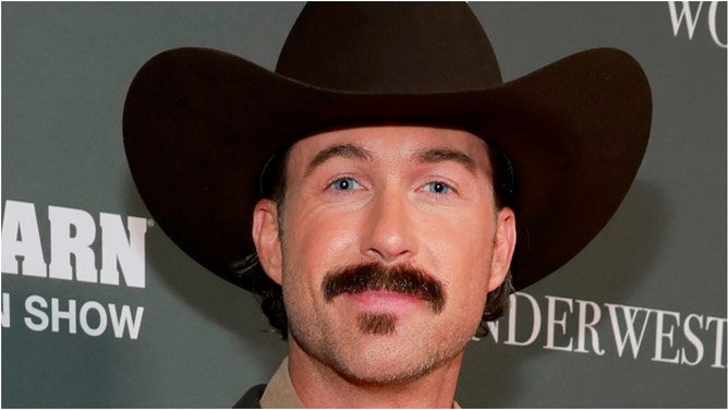 Country music star Riley Green surprised fans by shaving his iconic mustache. Check out a photo of his new look. (Photo by Jason Kempin/Getty Images for Boot Barn)
