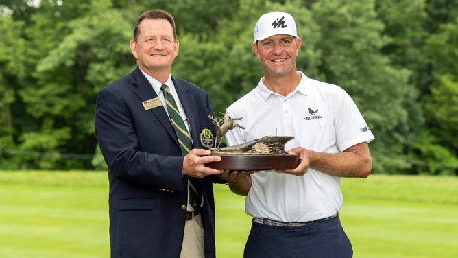 Lucas Glover holds up the trophy after winning the 2021 John Deere Classic at TPC Deere Run in Silvis, Illinois. (Photo credit: Marc Lebryk-Imagn Images)