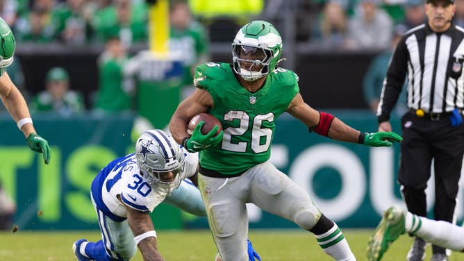 Philadelphia Eagles running back Saquon Barkley runs past Dallas Cowboys safety Juanyeh Thomas at Lincoln Financial Field.