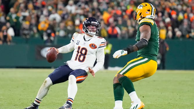 Chicago Bears QB Caleb Williams looks to pass while defended by a Green Bay Packers player.
