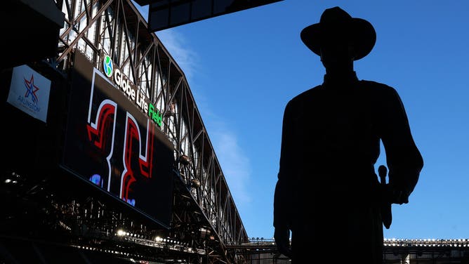 The "One Riot, One Ranger" statue is silhouetted by the sky visible from the open roof of Globe Life Field before a game between the Texas Rangers and Seattle Mariners at Globe Life Field on April 06, 2026.