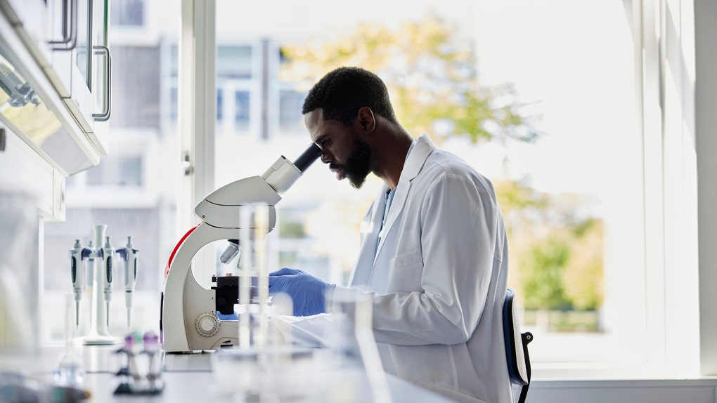 Scientist looking into microscope