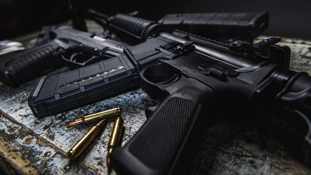 c6cc8d34-AR 15 with ammunition laying near it.