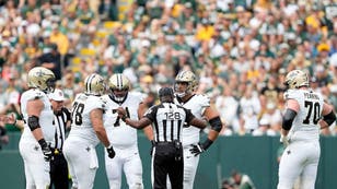 New Orleans Saints QB Derek Carr lays on the ground after getting hit by the Packers at Lambeau Field in Green Bay, Wisconsin.