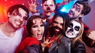 Friends in creepy costumes having fun at Halloween party