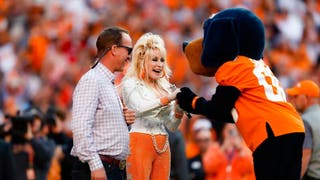 Peyton Manning escorts Dolly Parton onto the field at Tennessee. Courtesy of Tennessee Athletics