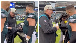 Eagles star Jason Kelce does a jersey swap with Jaguars coach Doug Pederson for his jacket. (Credit: Screenshot/Twitter Video https://twitter.com/JClarkNBCS/status/1576675973466320896)