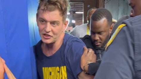 Michigan fan detained by police following national championship win in college football playoff, with son watching and pleading with police