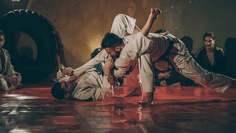 Group of people watching two man fighting on martial arts training.